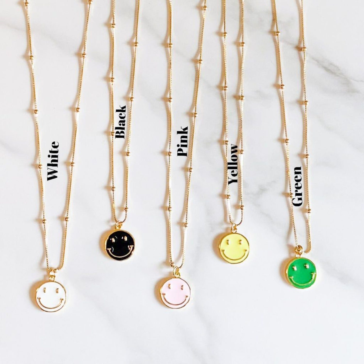 Happy necklace, gold-filled chain and an enamel pendant, available in white, black, pink, yellow, and green to be trendy and fashion by ISVI Boutique, Miami