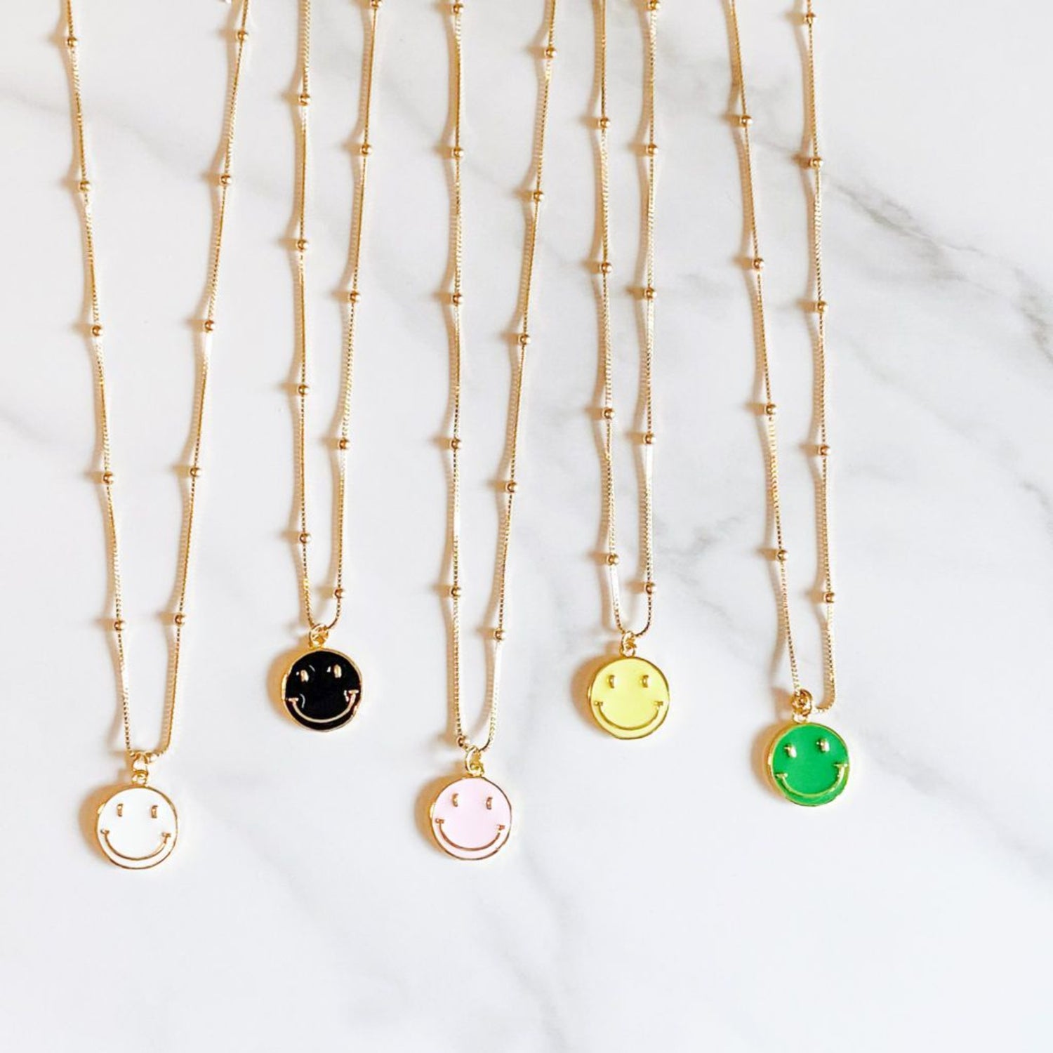 Happy necklace, gold-filled chain and an enamel pendant, available in white, black, pink, yellow, and green. Selected by ISVI Boutique, Miami