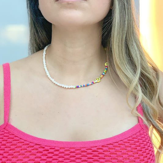 Rainbow Beads Smiley Face Necklace, gold-plated over brass, handmade by ISVI Boutique Miami with freshwater pearls, ceramic happy faces, and multicolor plastic beads. 14” length and 2” extender.